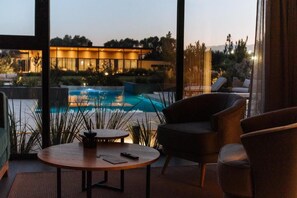 Un interior moderno con vista a una piscina, una mesa redonda y un sofá.