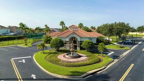 A building with a tiled roof, a fountain, and a parking lot. - Disney Princess Suite, Family Home, Sleeps 12 (Davenport)