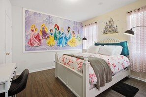 A bedroom with a large Disney princess mural, a white bed with teal headboard, and a desk with a chair. - Disney Princess Suite, Family Home, Sleeps 12 (Davenport)