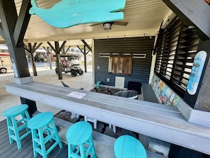 An outdoor bar area with wooden benches and a counter. - Pet-Friendly Ocean Lakes 3BR | Golf Cart | Sleeps 5 (Myrtle Beach)