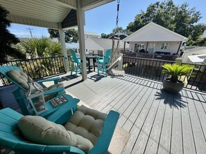 A wooden deck with outdoor furniture, including chairs and a sofa. - Pet-Friendly Ocean Lakes 3BR | Golf Cart | Sleeps 5 (Myrtle Beach)