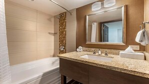 A modern bathroom with a bathtub, a sink, and a large mirror. - Oceanaire Virginia Beach - 1BR Ocean View Suite, Full Kitchen + Balcony (Virginia Beach)