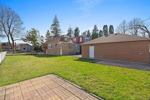 Um bairro residencial com casas, um gramado e um caminho pavimentado.