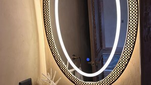 A bathroom vanity with a round mirror, a white sink, and a gold faucet. - La Mezquita Hotel & Spa (Jesus Maria)