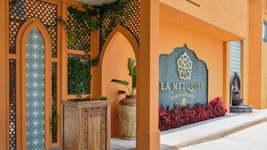 A hotel entrance with a decorative archway, a sign reading 'LA MEZQUITA CONCEPT HOTEL & SPA', and a statue. - La Mezquita Hotel & Spa (Jesus Maria)