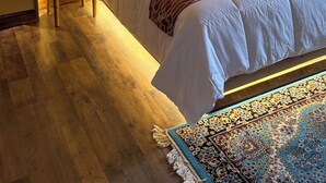 A hotel room with a large bed, a bedside table with a phone, and a decorative wall. - La Mezquita Hotel & Spa (Jesus Maria)