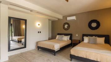 Une chambre d’hôtel avec deux lits, un miroir, un climatiseur fixé au mur et un élément décoratif circulaire sur le mur.