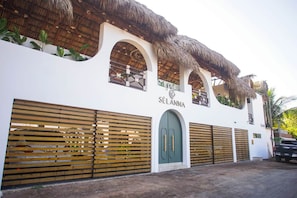 Edifici amb façana blanca, finestres apuntades i porta verda.