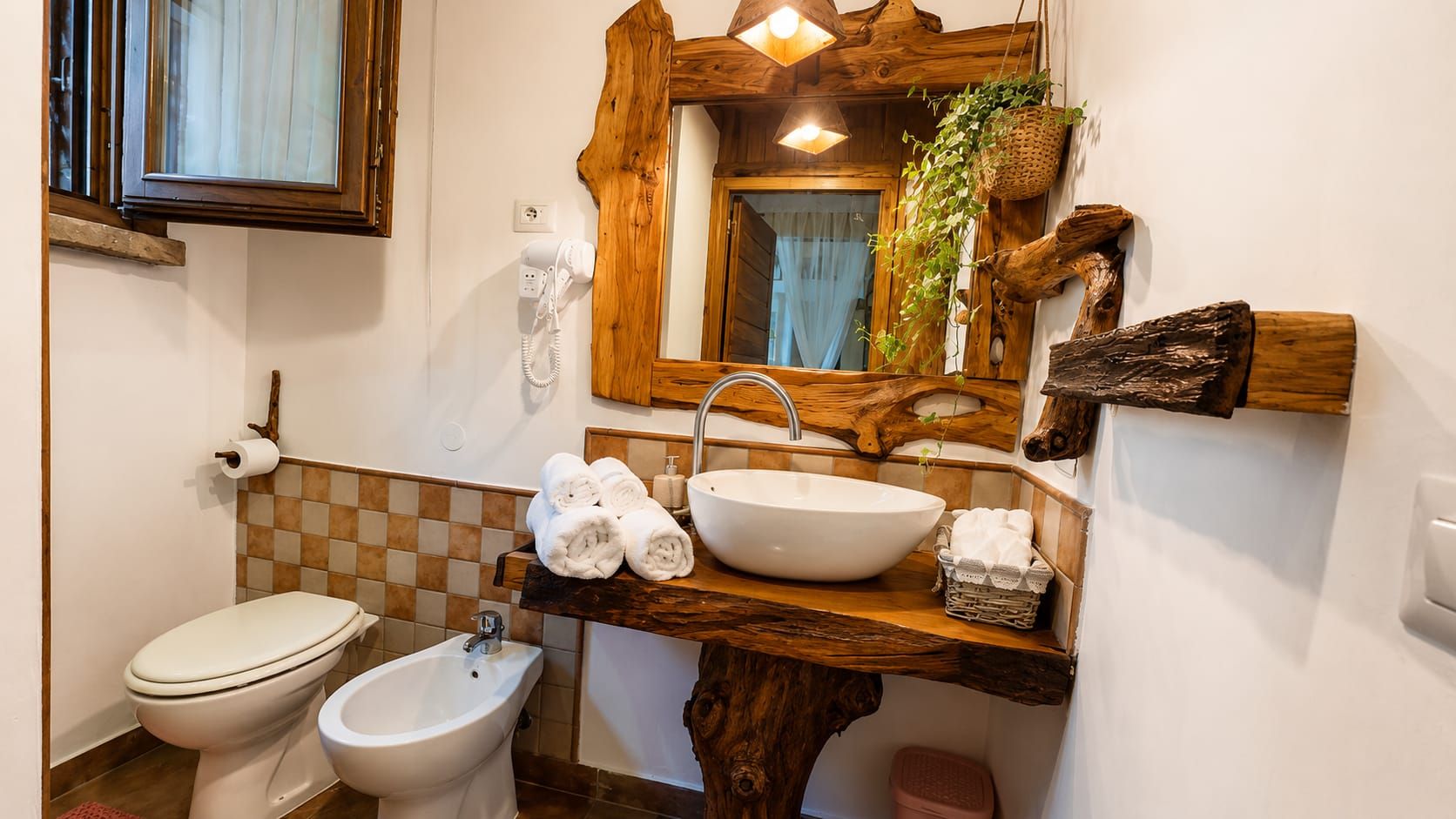 Casa de banho com sanita, bidé e lavatório.