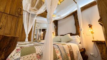Una camera da letto rustica con un letto a baldacchino, travi in legno e una lampada in stile vintage.