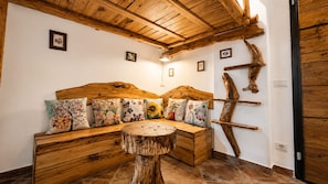 A cozy room with a wooden bench, a round wooden table, and a rustic wall decor.