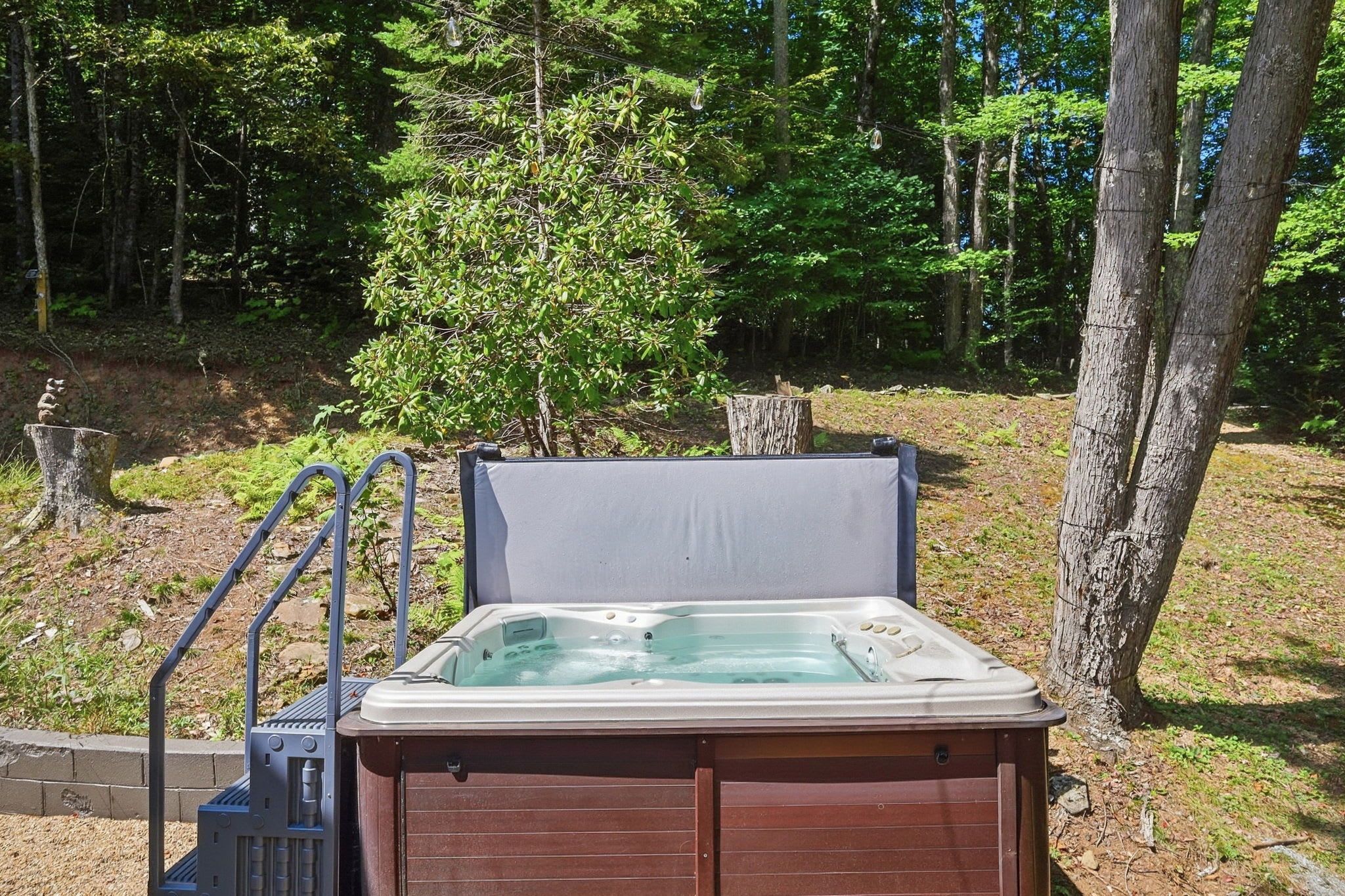 A hot tub in an outdoor setting with a wooden deck and metal railings.