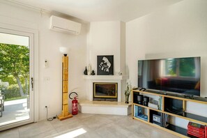 A modern living room with a fireplace, a mounted TV, and a bookshelf. - Family villa in the countryside of Oriago (Mira)