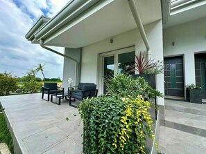 A modern outdoor patio area with a seating arrangement and potted plants. - Family villa in the countryside of Oriago (Mira)