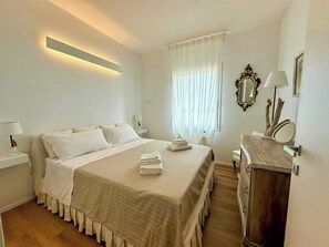 A hotel room with a bed, bedside tables, a dresser, and a window with curtains. - Family villa in the countryside of Oriago (Mira)