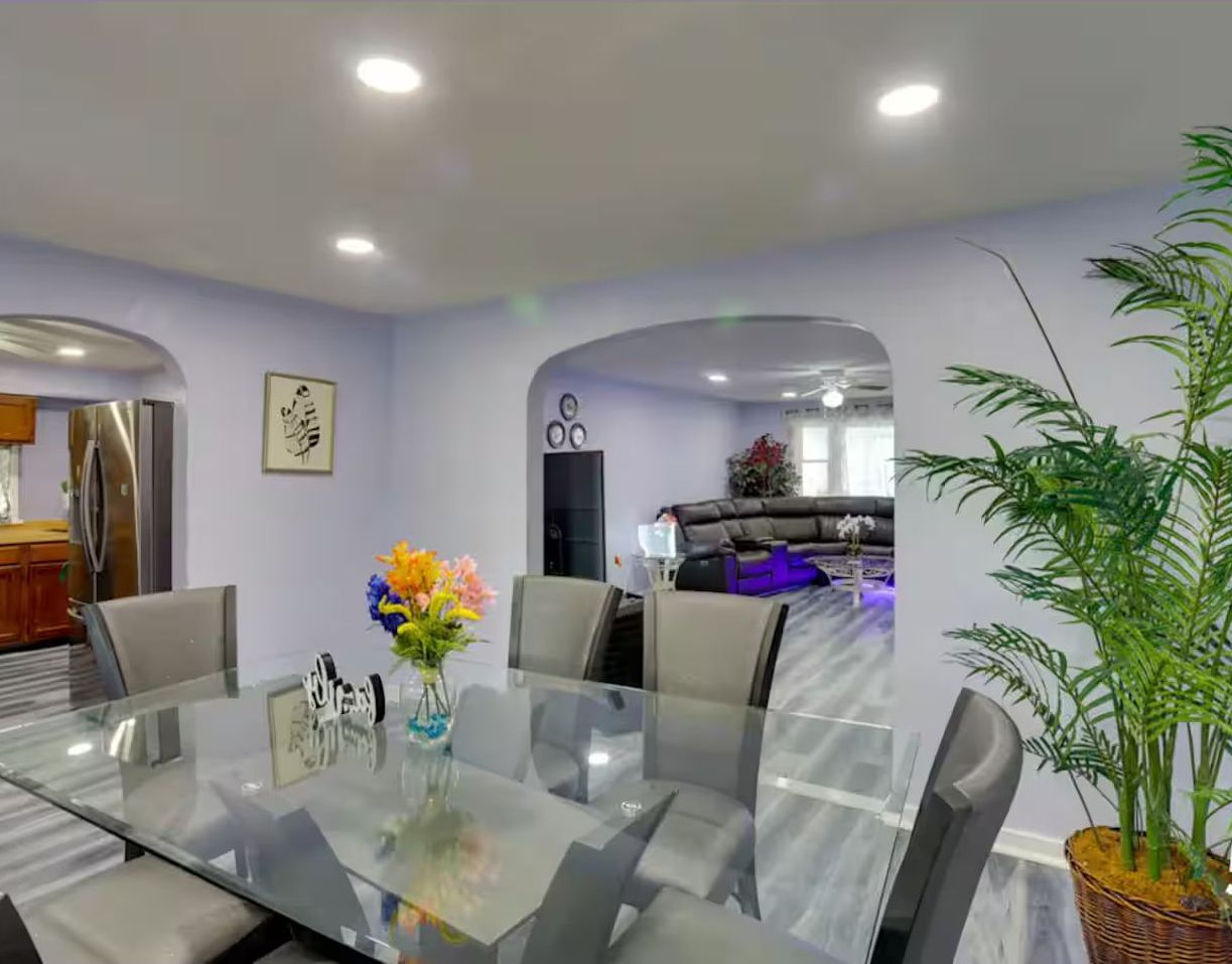 Dining area with a glass-top table connecting to the kitchen and living room.