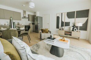 Ein modernes Wohnzimmer mit einer Couch, einem Couchtisch und einem Essbereich mit Stühlen und einem Tisch.