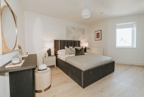 A bedroom with a bed, bedside tables, a mirror, and a window. - Boutique Luxury Apartment – 2 Bedroom, Sleeps 6 (London)