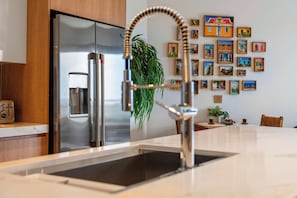 A modern kitchen with a stainless steel refrigerator, a built-in water dispenser, and a sleek faucet. - Top Floor Beach Condo|Near Eagle Beach|Pool&Jacuzzi (Pos Abou)