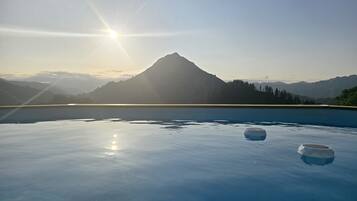 Ein ruhiger Pool im Freien mit Blick auf Berge, zwei Schalen und einem klaren Himmel.