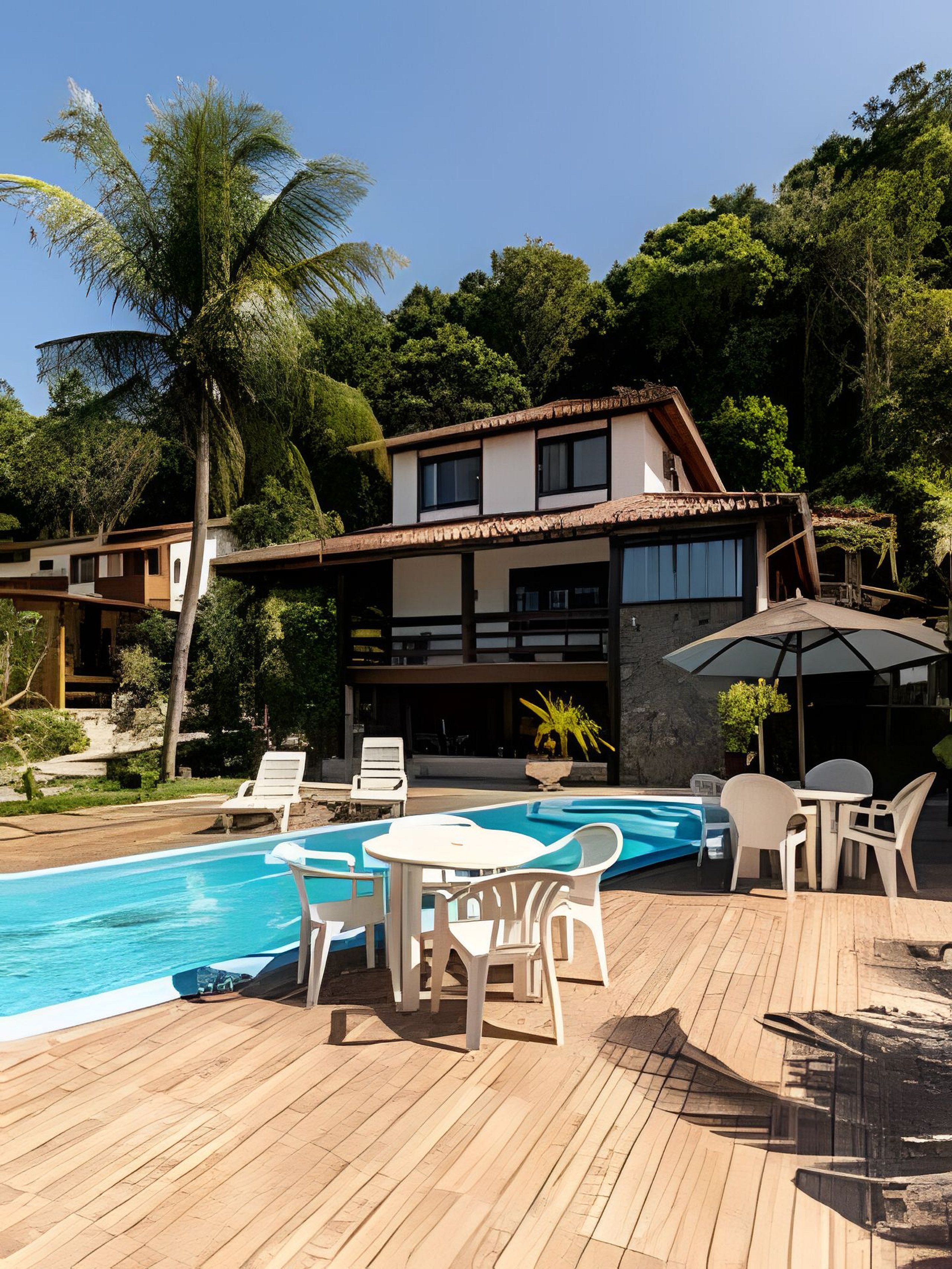 A modern house with a swimming pool, outdoor furniture, and lush greenery.