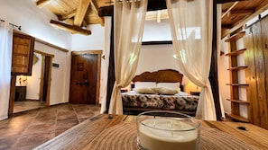 Una camera da letto con un letto, una testiera in legno e un comodino con una candela.