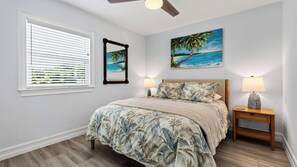 A bedroom with a bed, a nightstand, a lamp, a ceiling fan, a window with blinds, and two wall art pieces. - Sanctuary Point by Avantstay Waterfront Pool + Spa Kayak + Fishing Dock Near Beaches (Bonita Springs)