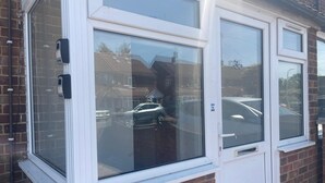 A window with a white frame, a door, and a small window below the main window. - Apartment Sleeps 7 With Patio (Hayes)