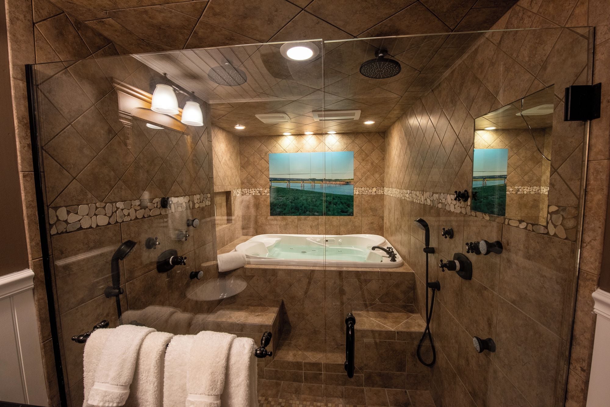 Un baño con una bañera grande, ducha y espejo.