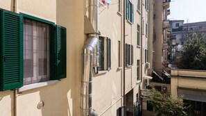 Ein mehrstöckiges Gebäude mit Außenklimaanlagen und Rollläden an den Fenstern.