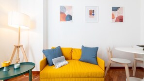 A room with a yellow sofa, two blue cushions, a white lamp, and a small table with a yellow vase. - [Corso Buenos Aires] Central and Cozy (Milano)