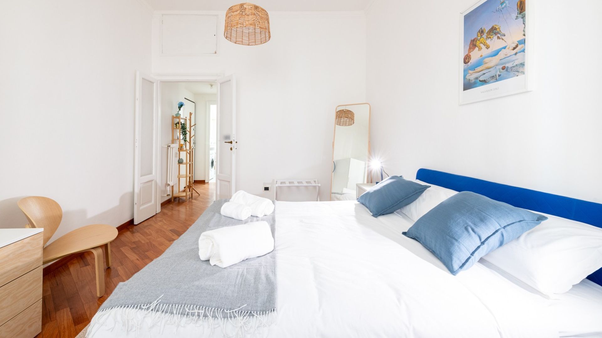 Un dormitorio con cama, mesita de noche y puerta que da a un baño.