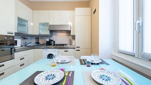 Une cuisine moderne équipée d’appareils électroménagers en acier inoxydable, d’un four encastré et d’un lave-linge.