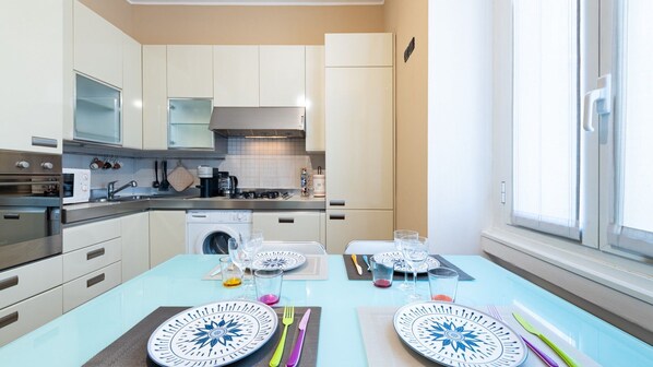 A modern kitchen with stainless steel appliances, a built-in oven, and a washing machine. - [Isola - Porta Nuova] Elegant 1BDR with Balcony (Milano)