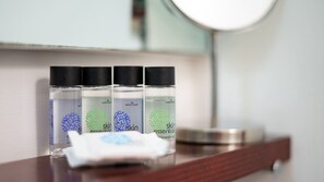 A bathroom counter with three bottles of skin essentials and a tissue. - [Isola - Porta Nuova] Elegant 1BDR with Balcony (Milano)
