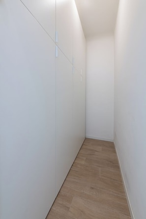 A narrow hallway with white walls and wooden flooring. - [Metro M1] Quiet & Modern Apt near Center (Milano)