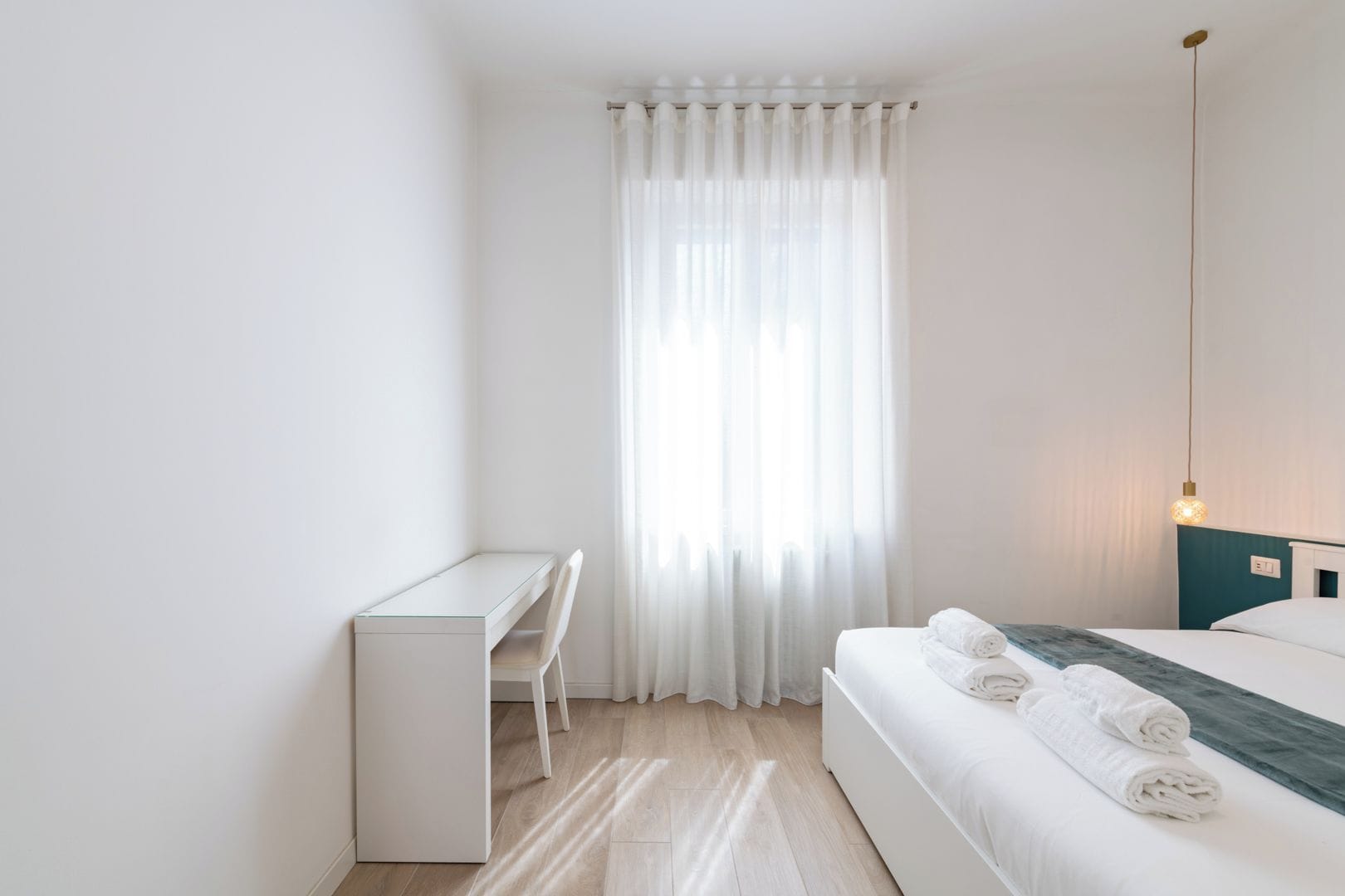 Ein Schlafzimmer mit einem Bett, einem Schreibtisch und einem Stuhl.