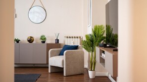 Ein modernes Wohnzimmer mit einer Couch, einem runden Spiegel und mehreren Blumentöpfen.