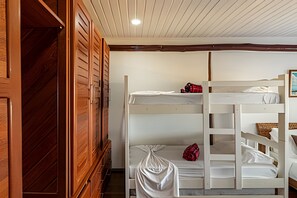 Ein Schlafraum mit Etagenbetten, Holzwänden und einer weißen Decke.