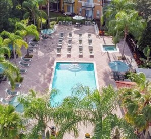 A pool area with lounge chairs and palm trees. - 4BR Townhouse- Near Disney (Kissimmee)
