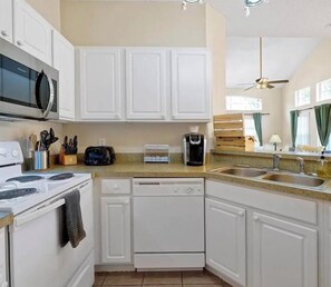 A kitchen with white cabinets, a microwave, a toaster, and a dishwasher. - 4BR Townhouse- Near Disney (Kissimmee)