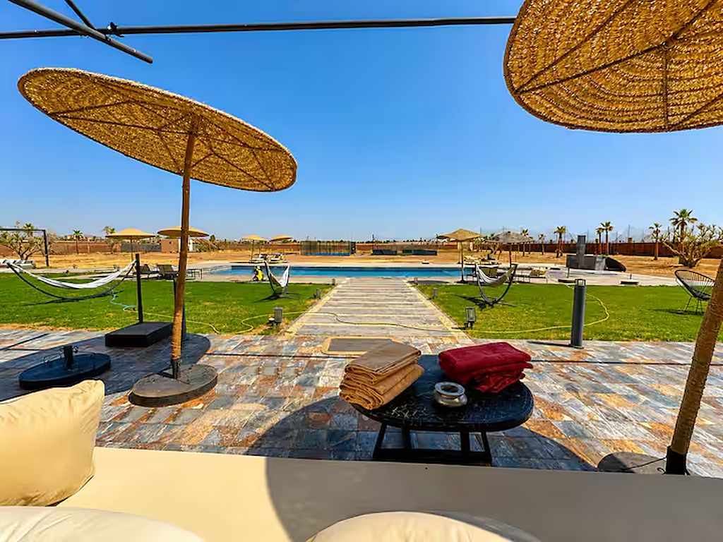 A poolside area with umbrellas, lounge chairs, and a view of the pool.