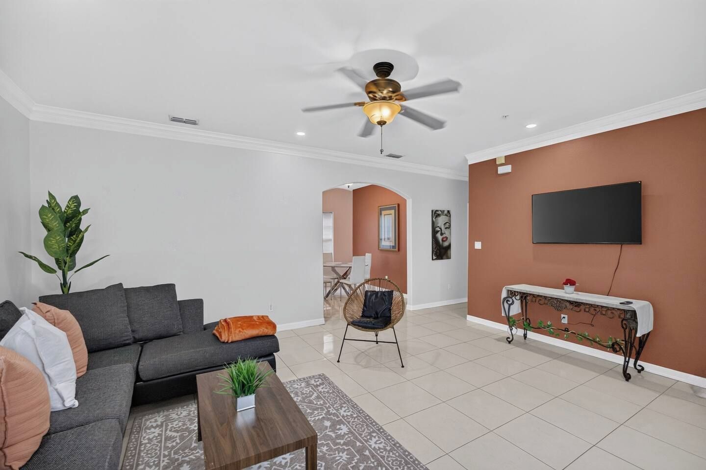A modern living room with a sofa, coffee table, and a ceiling fan.