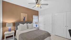 A bedroom with a bed, nightstands, a ceiling fan, and a wardrobe. - Terracotta Central Spacious 2Bed/2bath Comfy Calm (McAllen)