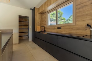 Eine moderne Küche mit Holzrückwand, einem Fenster mit Aussicht und einer eingebauten Regaleinheit.