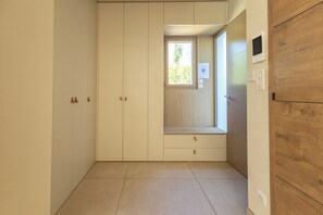 A room with a built-in wardrobe, a small window, and a wooden panel on the right wall. - Villa d’architecte avec piscine - Entre Marseille, Cassis & les Calanques (Aubagne)