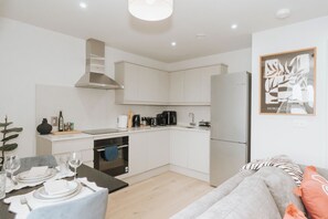 A modern kitchen with white cabinets, a built-in oven, and a refrigerator. - Stylish 1-bed Apt in Clapham - 1 Minute from tube (London)