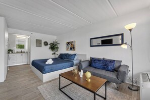 A modern bedroom with a bed, a sofa, a coffee table, and a desk. - Studio Escape 7 min to Disney World +Parking | Orl (Kissimmee)