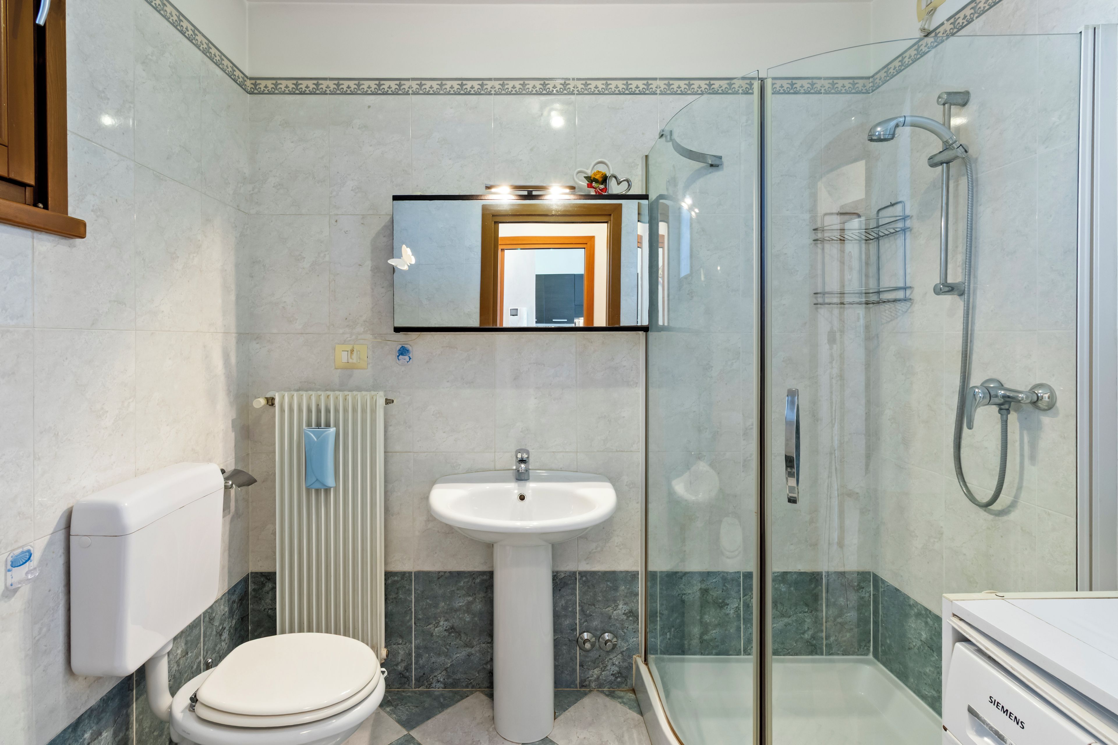 A modern bathroom with a toilet, sink, and shower.