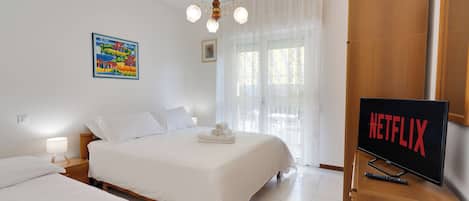 Una habitación de hotel con una cama, un televisor y un cuadro en la pared.